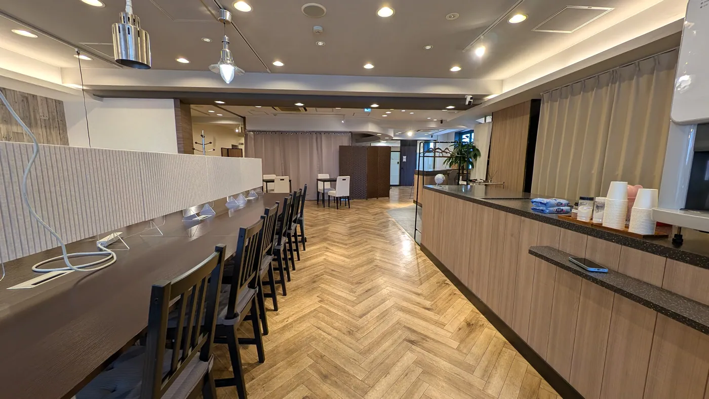 カップが並ぶドリンクカウンターと、パーテーション付きの長机