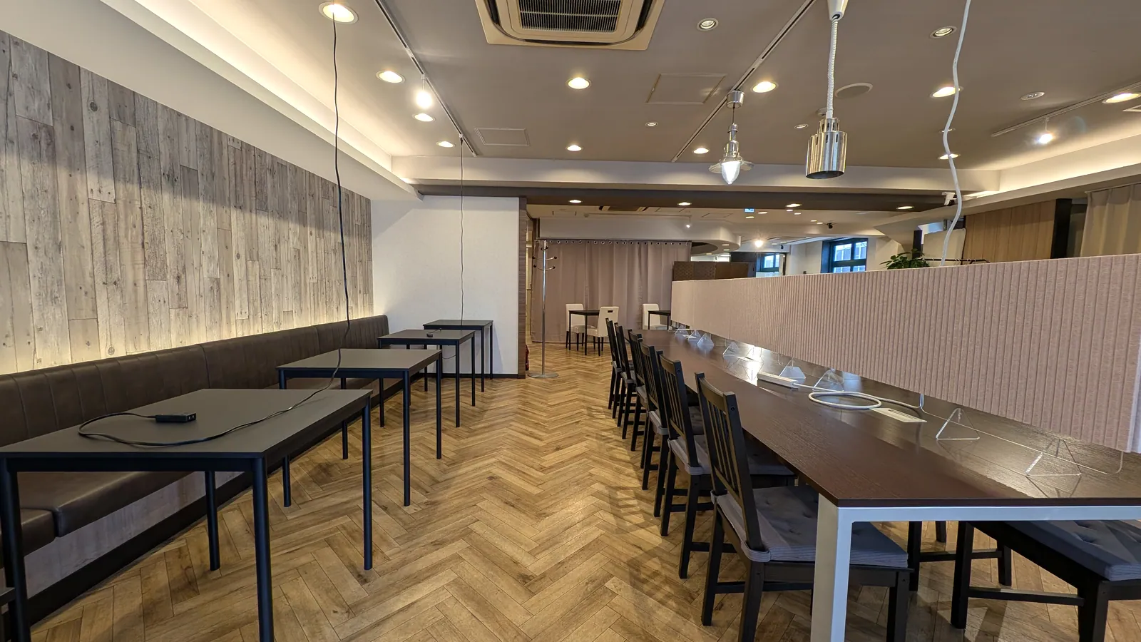 MACHITOSHO+loungeのテーブル席と、中央にパーテーションを設置した長机