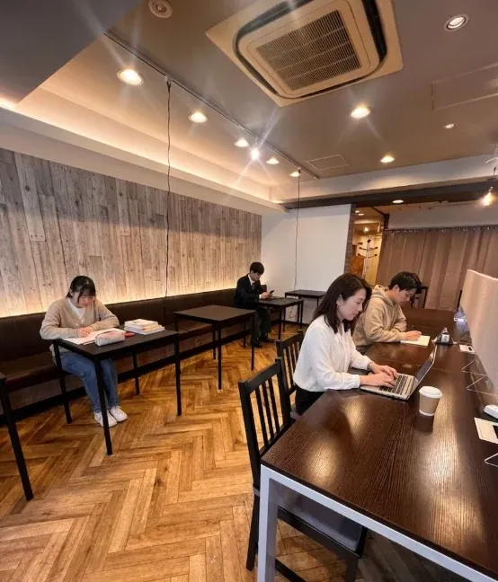長机でノートパソコンを使って作業する利用者