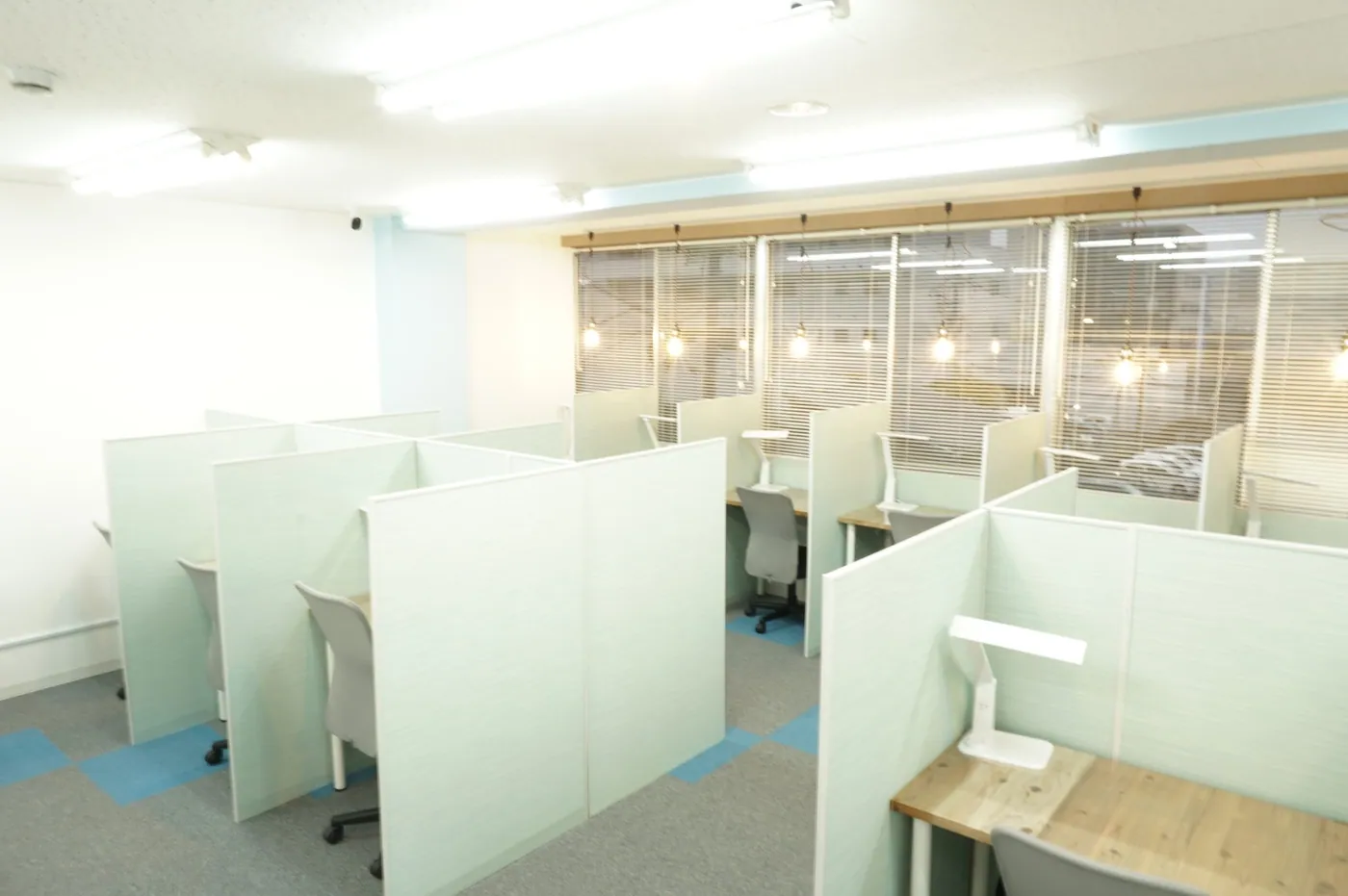 パーテーションで区切られ、机ごとに照明を備えたまち図書カフェの自習席